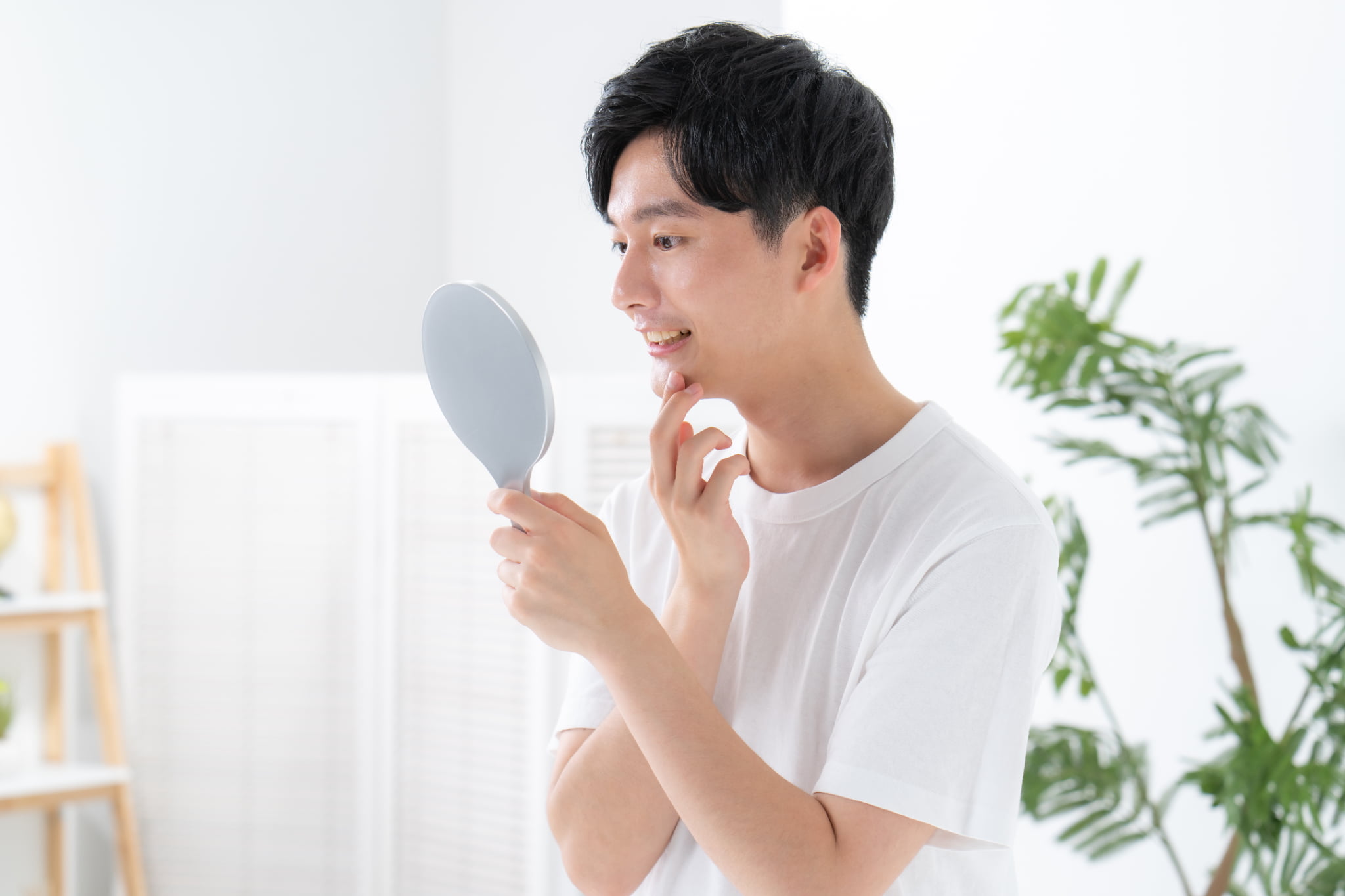歯周病症状のセルフチェックをする男性