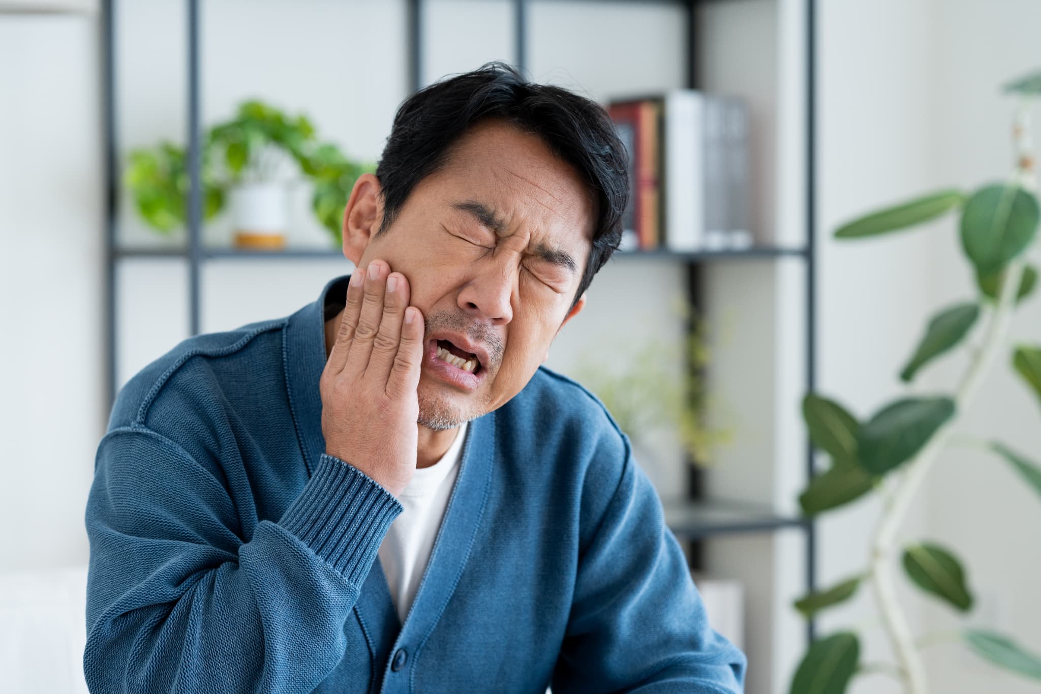 虫歯になった歯をを痛がる男性
