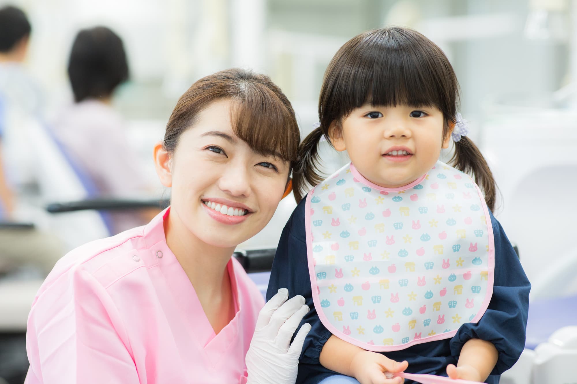 歯科検診にきた女の子と歯科衛生士の女性