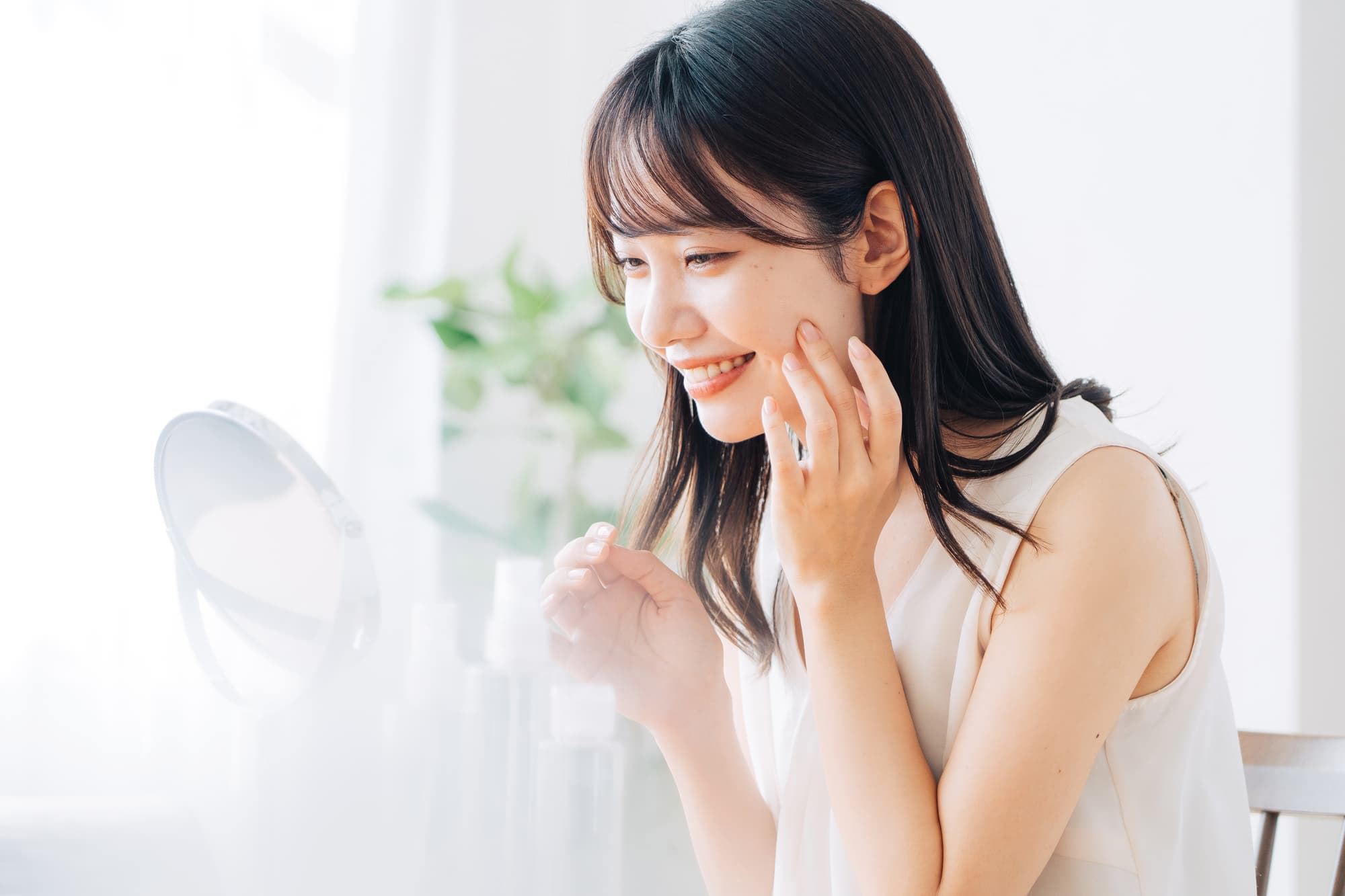 マウスピースで八重歯の治療をして嬉しそうに鏡を見る女性