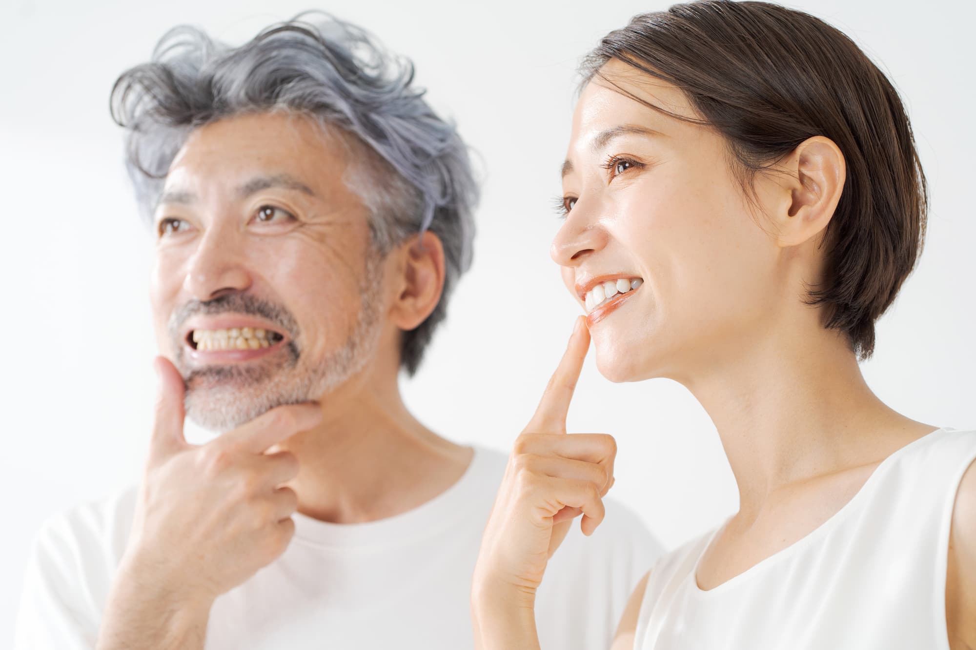 インプラント治療した歯を指さす男女