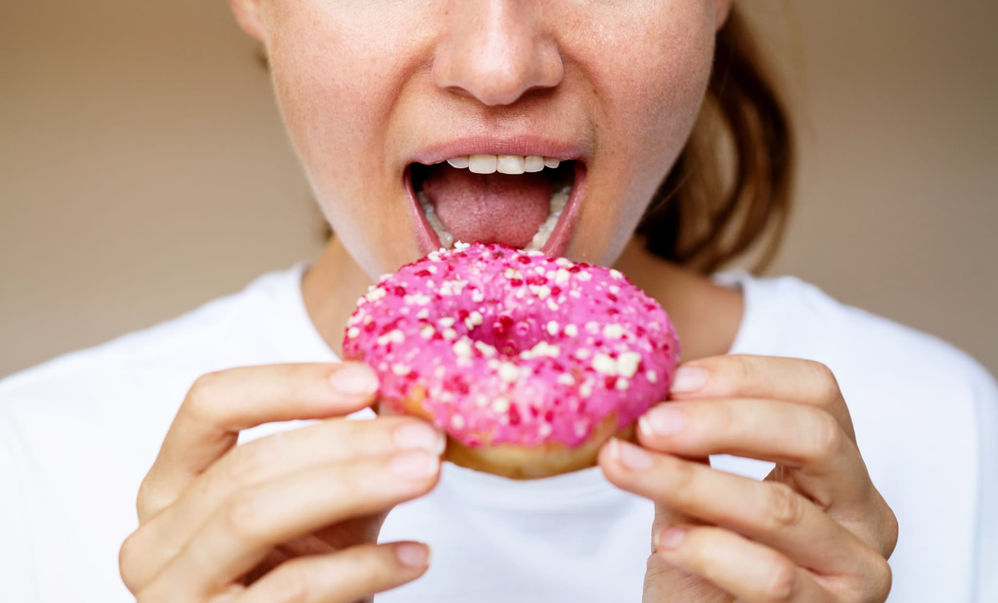 歯周病を悪化させる糖分の多いドーナツを食べるイメージ